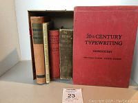 Set of five vintage cloth bound books arranged side by side, one with a red cloth cover titled '20th Century Typewriting'
