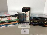 Full view of all DVDs stacked and lined up including various movies and travel guides with an audio CD