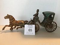 Full view of cast iron horse and carriage figurine with auction lot tag