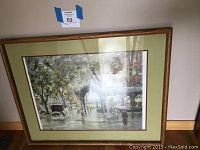 Framed print showing full artwork in wooden frame with green matting.