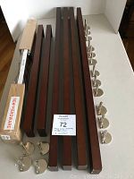 Four 36-inch and three 24-inch Milano Series wooden shelves, metal brackets arranged beside shelves on a white table surface. One 24-inch shelf still in packaging labelled 'NEW HARDWARE'.