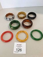 Eight bangles laid flat on white surface, front view