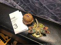 Photo showing the dragonfly solid perfume container and the separate pumpkin trinket box together on a surface