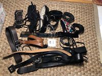 Photo showing a mixed lot of ladies belts including leather, braided fabric, and patterned belts in various styles and buckle types.