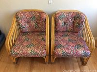 Pair of bentwood chairs with floral cushions placed side by side, showing front view.