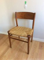 Full front view of teak chair showing frame and woven seat