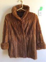 Front view of the brown vintage fur coat showing full length and rolled sleeves on a hanger.