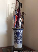 Front side view of the umbrella stand and umbrellas showing pattern and color details