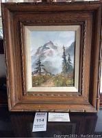 Framed oil on canvas painting showing entire piece with a wood frame and visible matting, landscape with mountain, trees, and path.