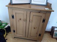 Front view of natural pine wood wash stand cabinet with double doors and wooden knobs, showing the overall size and style.