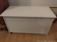 Front view of the white melamine chest showing the solid rectangular form and clean white finish.