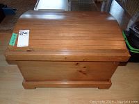 Front view of small solid wood chest showing rounded humpback lid and wood grain
