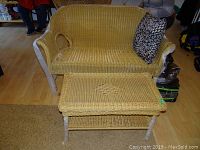 Wicker bench and matching table set with pillow from front viewpoint showing bench shape, table surface, and pillow placement.