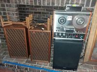 Front view showing two wooden lattice front speakers and TEAC reel to reel recorder with wiring on top
