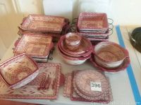 Photo showing full set of TempTations ceramic ovenware with varied rectangular and round pieces, mainly red and cream with floral leaf designs.
