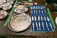 Complete view of the silver plate tray, fish cutlery set in cloth holder showing texture and detail on handles, and gravy boat with its tray.