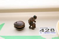Two carved netsuke pieces displayed side by side on a light surface, showing top and side angles.