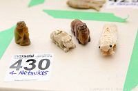 Top view of four netsuke arranged side by side showing shapes and relative sizes