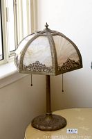 Full front view of lamp showing slag glass shade and metal base