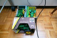 Three boxed John Deere metal tractor toys including one 1953 Model D Tractor with original packaging visible from front.