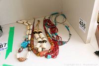 Photo of five necklaces including two turquoise stone necklaces, various bead styles and colors visible.