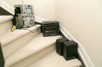 Yorx music system stereo unit, two black speakers, and Nexxtech karaoke machine on stairs.