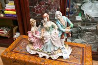 Wide angle photo of the porcelain china tableau showing three figures, piano, and base