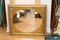 Full view of the ornate gold frame mirror with oval mirror inset, showing condition and size
