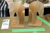 Pair of alabaster horse head bookends on a countertop, showing full front profile and color variations.