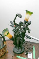 Full view of the lamp showing metal figurines and two art glass floral lamp shades with cord and switch visible.