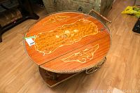 Top closeup showing inlaid wood design and brass trim