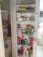 Image of pantry shelves containing cleaning chemicals including Raid, Windex, Pine-Sol, Cascade, gloves, cleaning sponges, and other supplies neatly organized on wire racks.