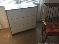 Photo of small white 3-drawer chest under window
