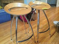 Both stools full view on hardwood floor with bins and household items in background