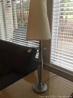 Single 31-inch metal Ethan Allen table lamp with slender silver base and conical off-white paper shade.