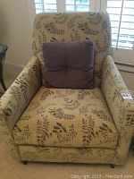 Front view of the McCreary modern upholstered chair with fern leaf print fabric and purple cushion on the seat.
