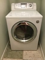 Front view of white LG Tromm front-load dryer with silver-trimmed door.