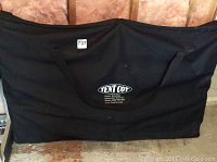 Black Tent Cot inside a black carry bag with printed logo and contact information.