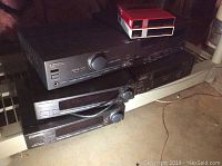 Stack of five black Pioneer stereo components including amplifier, tuner, CD player and tape deck with two Pioneer speakers visible.