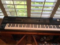 Front view of Roland XV-88 synthesizer on stand showing overall appearance and key layout