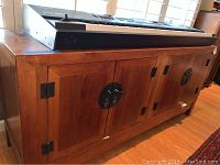 Full side and front view of a wooden cabinet showing wood grain, construction and metal hardware.