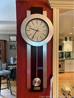 Full view of Howard Miller pendulum clock mounted on wall