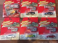 Six Johnny Lightning diecast cars in original blister packaging, shown together to display lot contents and condition.