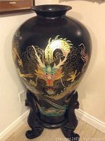 Full view of large black vase with colorful dragon and included wooden stand