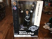 Front view of boxed Wayne Gretzky hockey figure, showing figure behind clear plastic, box featuring NHL and LA Kings logo.