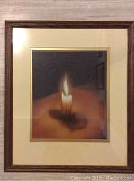 Framed pastel artwork showing a single burning candle with soft shadows, signed by Peter Chrighton.