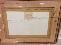 Back of watercolor painting frame showing taped edges and label
