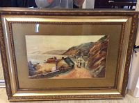 Full view of antique watercolor painting framed, showing coastal village with boats and hills, frame visible with damage.