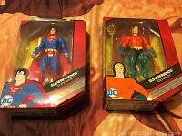 Front view of two boxed DC Comics Super Friends 2017 figures featuring Superman and Aquaman.