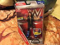 Front view of A J Styles WWE SmackDown Live figure in original sealed packaging showing figure, blue boots, and jacket.